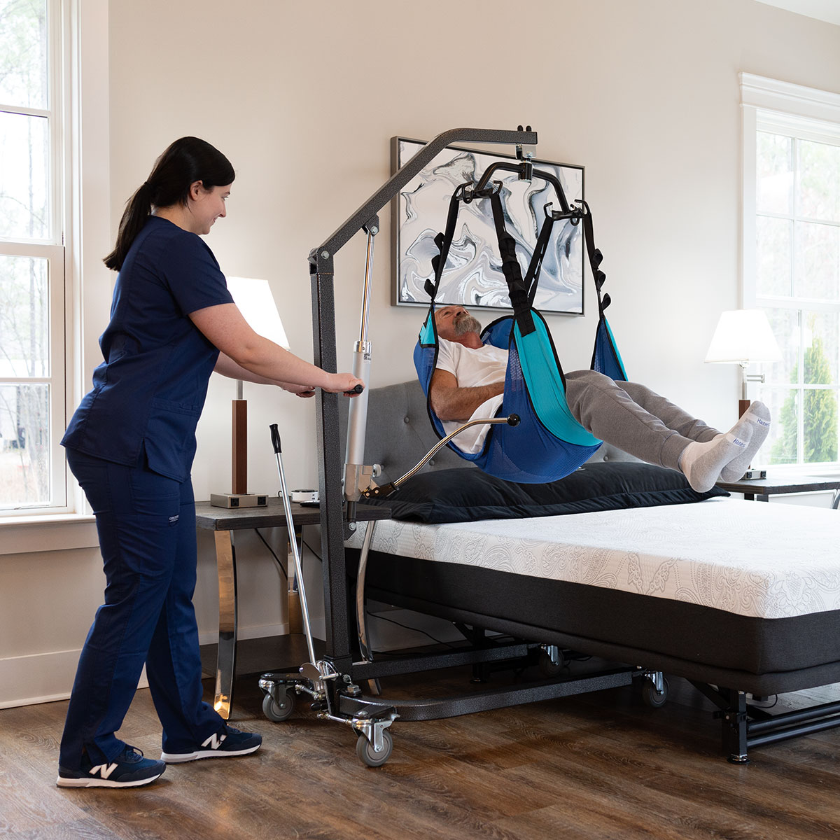 Caregiver using a patient lift with a Flex-A-Bed Hi-Low SL